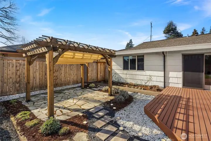 Covered patio area provides shade on hot days. Low maintenance landscaping with white rock pathway for contrast!