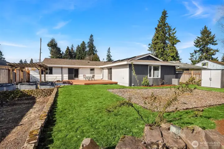 Oversized, fully fenced backyard with RV parking, large lawn area, entertaining deck and covered patio.