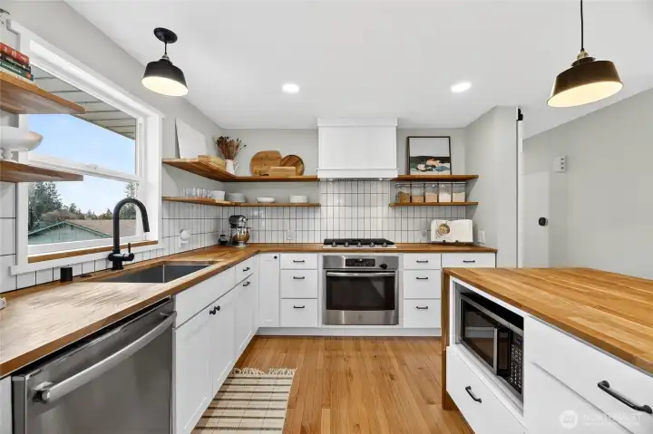 Pendant lights. Stainless steel appliances, Butcher Block countertoops.