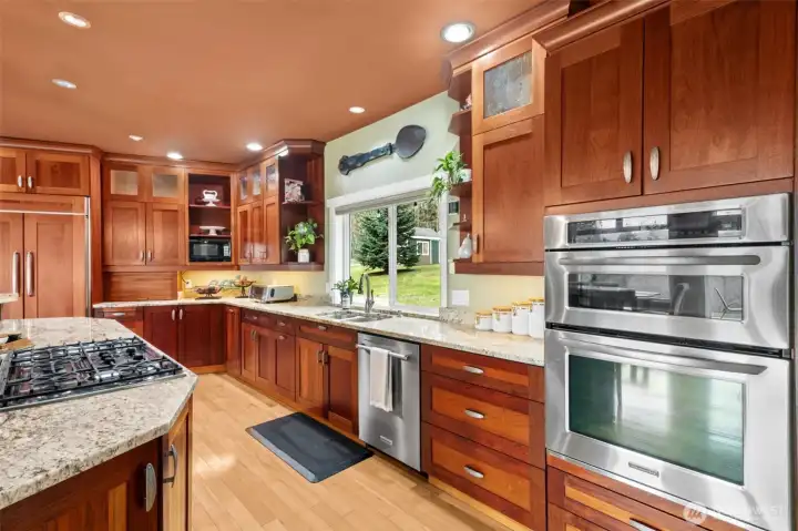 The owner/builder was a kitchen designer by trade and this kitchen was lovingly designed and executed with the Chef in mind. Ceiling height, Brazilian Cherry cabinetry with rain glass detailing, upper cabinets are 15" deep. Expansive Solid granite counters, Island with Bar Height eating, and work stations. 150# full extension Hardware, Built in Kitchen Aid Refrigerator and 21" deep pantry, a second additional pantry has been added for even more storage. Double convection ovens-top oven microwave and lower regular or convection option.