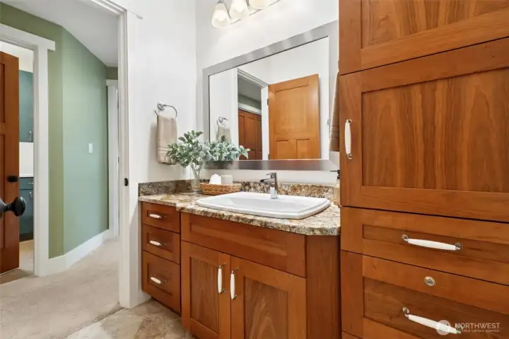 Full Guest bath with granite counters and generous storage cabinetry. Toto toilets offer low water use. Lovely Cherry cabinetry and lockable RX cabinet.