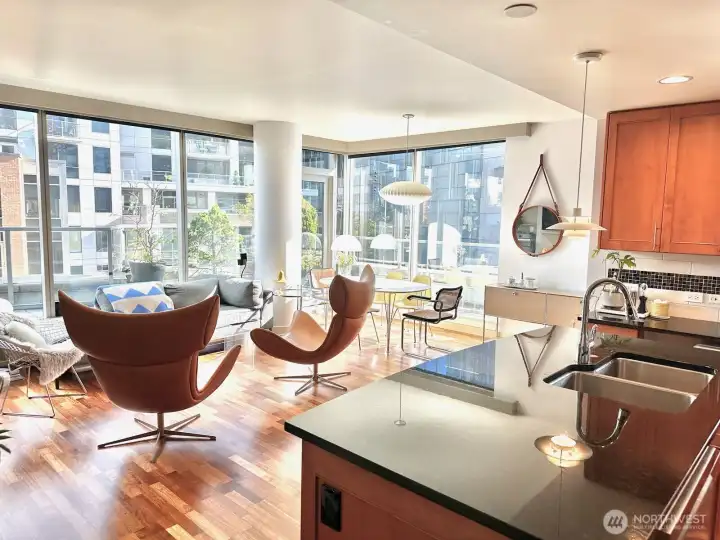 Living and dining area flowing into the kitchen with modern finishes and city outlooks.