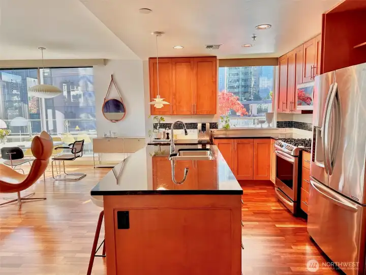 Chef’s kitchen with warm cabinetry, stainless steel appliances, and generous counter space.
