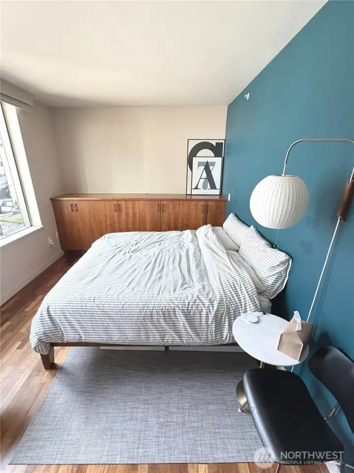 Comfortable bedroom with natural light and calming color palette.