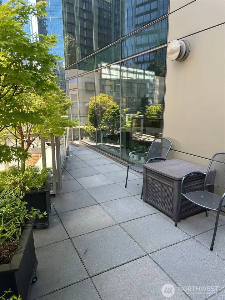 Private outdoor living area with seating and landscaped planters.