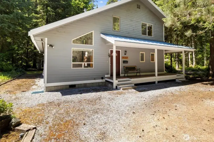 Covered front porch entry with a warm, welcoming cabin feel.