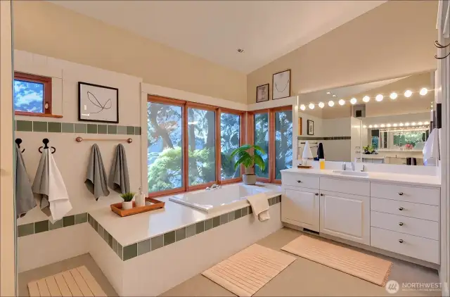 Primary bath with generous soaking tub looking over East sound and no step walk-in shower - virtually staged