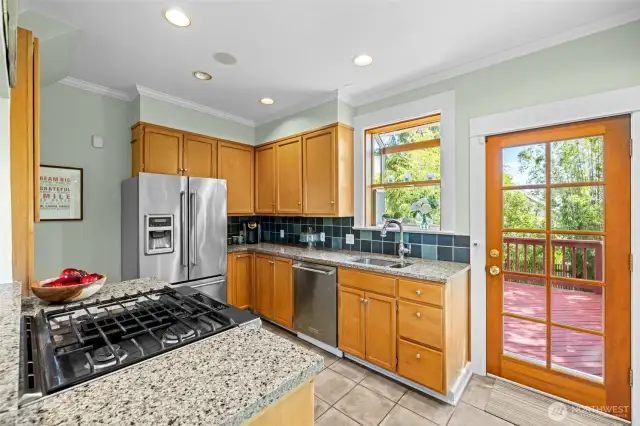 Stainless appliances, & gas range with tiled floor is sunny and bright
