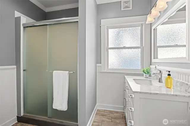 Updated hallway 3/4 bath with marble sink counter top and tiled flooring