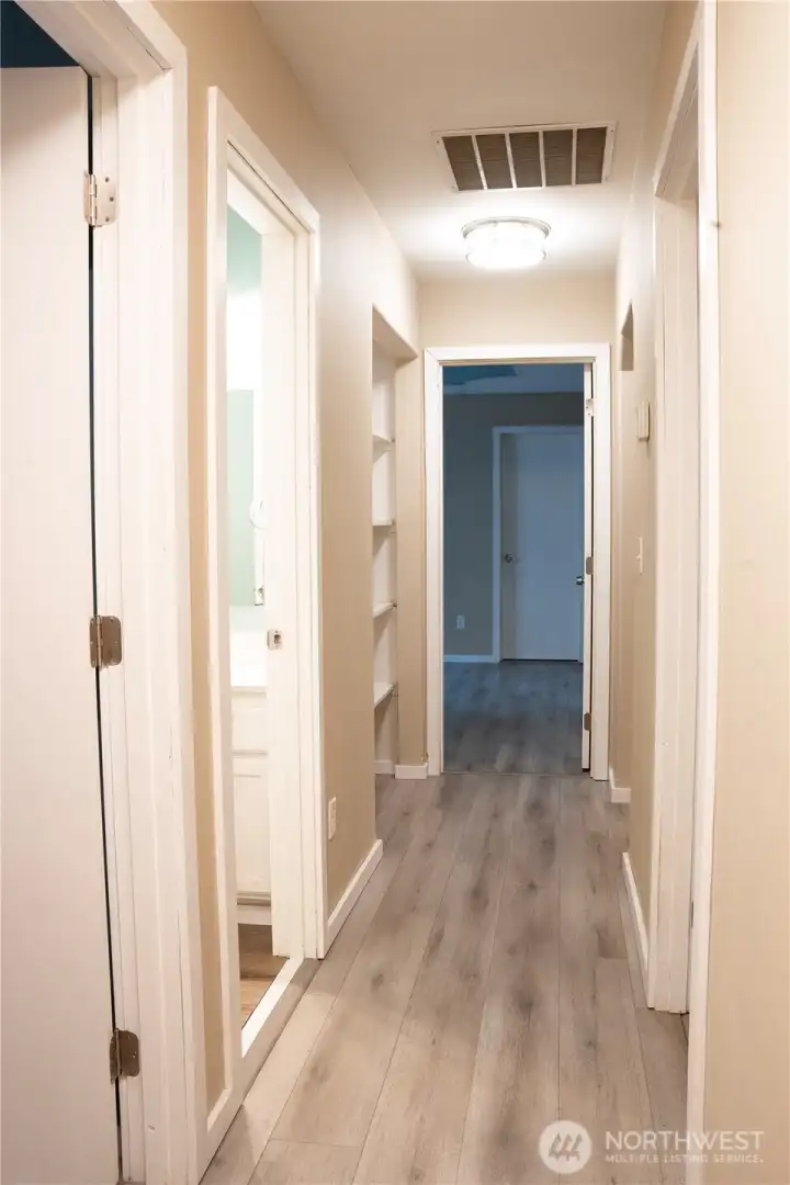 You can go down the hallway that guides you to the second and third bedroom with the laundry at the end of the hallway. Inviting you into a functional and well-connected space.