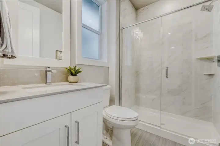 A stylish ensuite bathroom complements the spacious second bedroom on the upper floor.