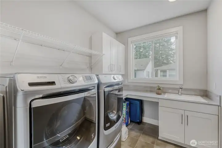 Sun-filled and spacious, the second-floor laundry room offers a full sized W/D and generous counter space with built-in storage for effortless organization.