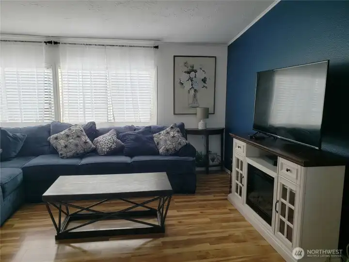 A Different View of the Enormous Open Living Room with Cathedral Ceiling, Newer Laminate Flooring Looking at the Entertainment Center.