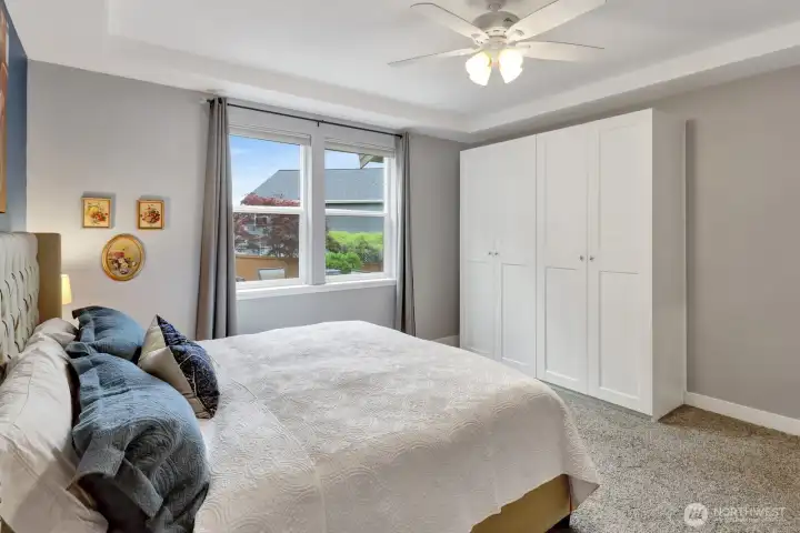 Primary suite with tray ceiling and natural light with views of the backyard. Extra built-ins in addition to the walk-in closet