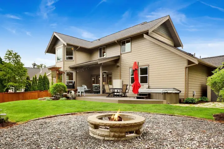 Backyard fire pit area with mature landscaping