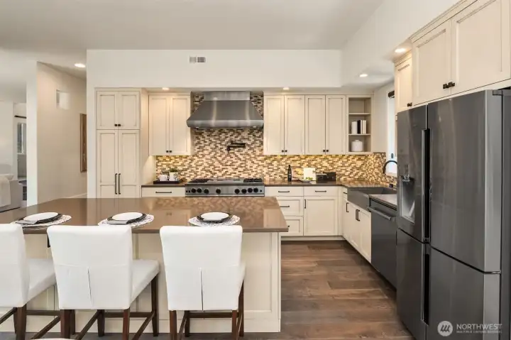 Special touches include: double ovens, two wine fridges, and a wall-mounted pot filler.