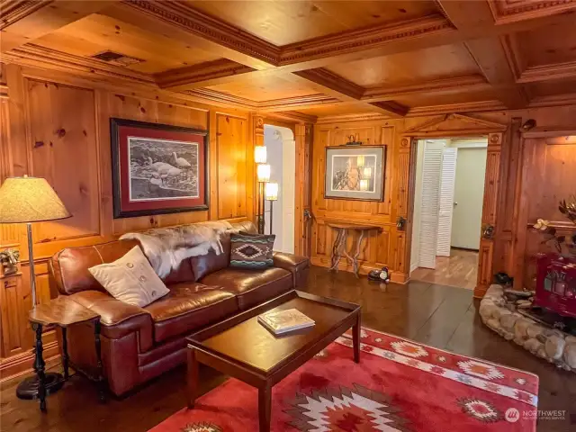 Luxurious parlor complete with a beautiful free-standing stove and masterfully created knotty pine walls, ceiling and decorative molding.