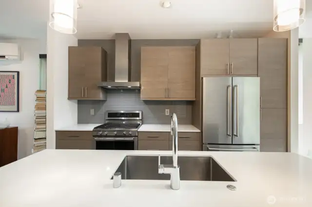 Sleek cabinetry, stainless appliances, and a spacious island anchor the heart of the home.
