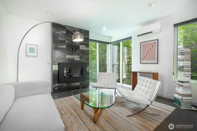 Stylish fireplace and large windows bring warmth and light into the living room.