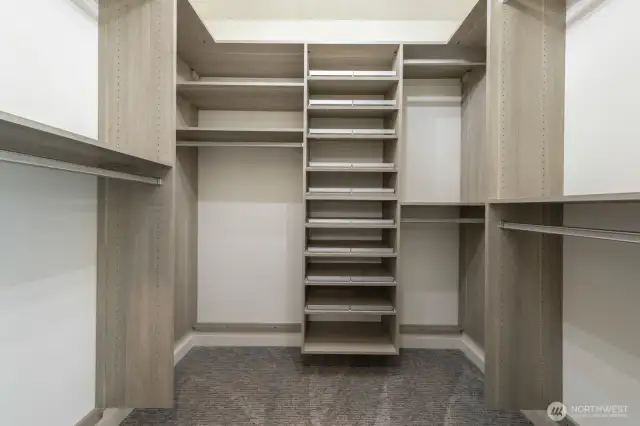 A thoughtfully designed walk-in closet with California Closet built-ins and ample storage space.