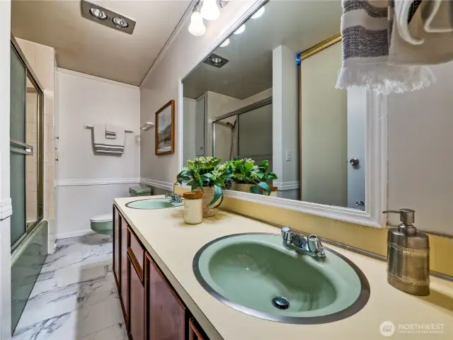 Spacious full bathroom featuring dual sinks and a double linen closet for generous storage