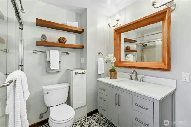 Another view of the bathroom and the storage-filled vanity. Even the toilet paper holder has storage, and below that is a laundry chute!