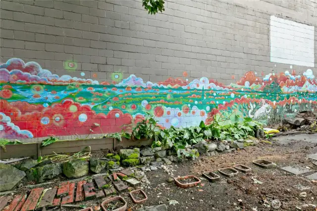 The Michael O'Driscoll mural spans across the wall--the wall is to the adjacent warehouse and provides a lovely shield from the noise and hot sun. The garden bed along the wall has calla lilies that are spectacular in the spring.