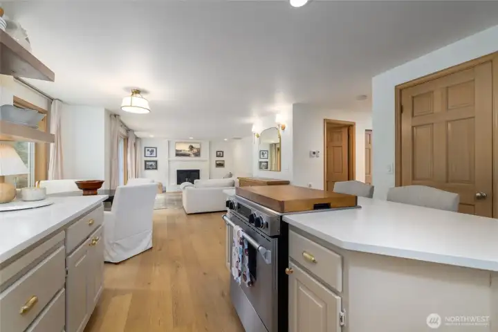 A view from the kitchen through the breakfast nook to the family room.  Closed door at far right is the step-in pantry, open door at left is the main floor powder room.