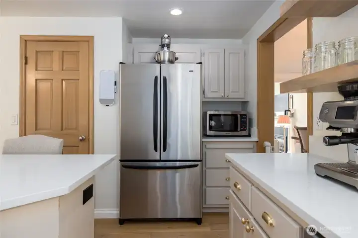 Another view of the kitchen, with pantry at left.  Formal dining through the doorway at right.  Quartz counters.