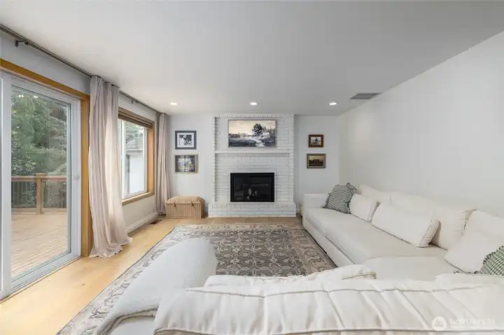 Family room.  Engineered hardwood plank flooring continues throughout main floor.  Large slider opens to new wood deck.  Fireplace.