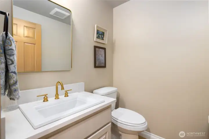 Updated main floor powder room has all new flooring, quartz counter, fixtures and hardware.