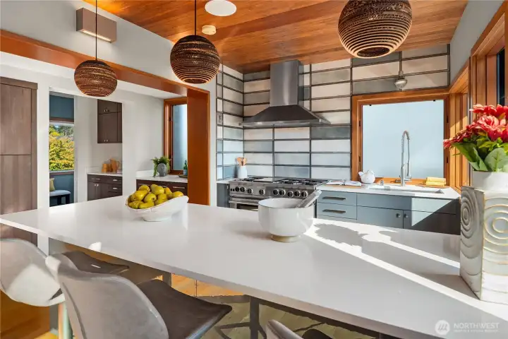 Crisp modern lines meet warmth and function, highlighted by a striking backsplash and generous counter space.