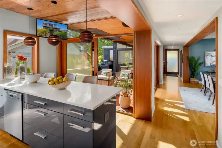 The oversized island anchors an open layout, seamlessly connecting the kitchen to indoor and outdoor living.