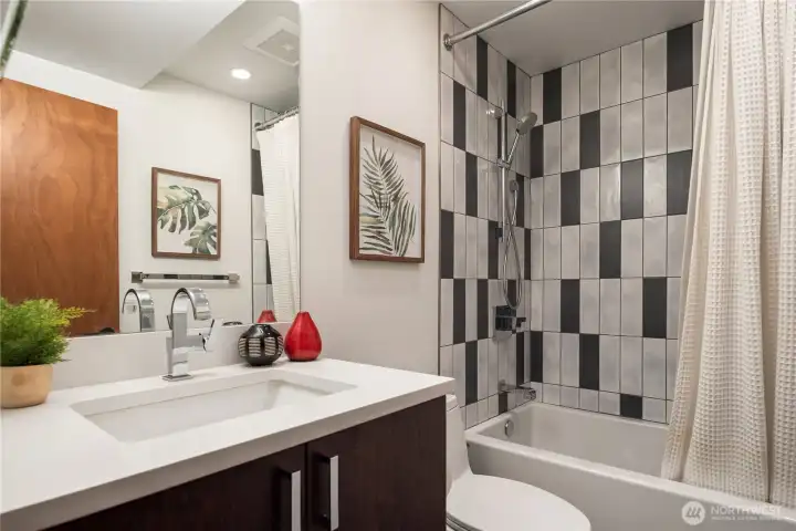 A chic full bath with striking black-and-white tile brings energy and modern style.