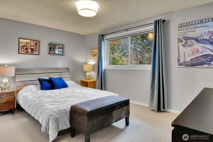 The primary suite offers a restful retreat, featuring a large window framing peaceful backyard views.