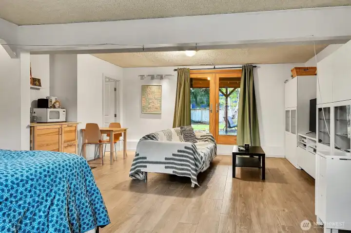 The lower level lives comfortably as a mini suite, offering a bedroom area, expansive living space, and a handy mini kitchen with a sink.