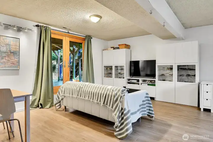 Heated LVP floors keep the lower level cozy, and there's access to the backyard through the gorgeous french doors!