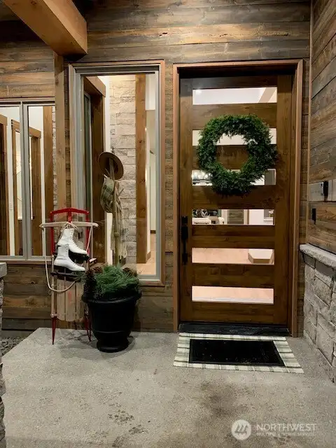 Welcoming covered front porch with modern glass door.