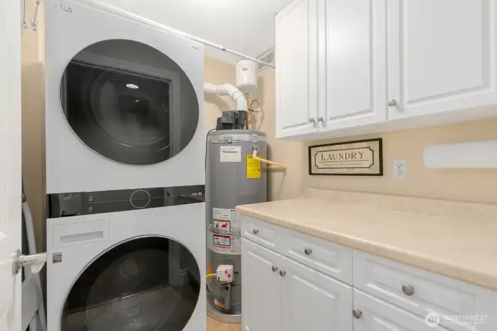 Spacious laundry room offers functional countertop with built in cabs.