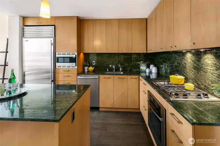 Gorgeous kitchen with premium appliances, gas cooktop, granite slab counters, under cabinet lighting and lots of cabinet storage.