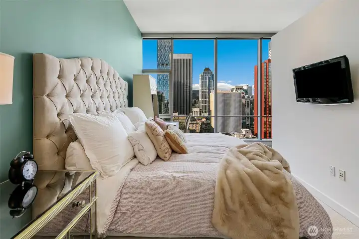 Dreamy bedroom with the city lights to entertain day and night.