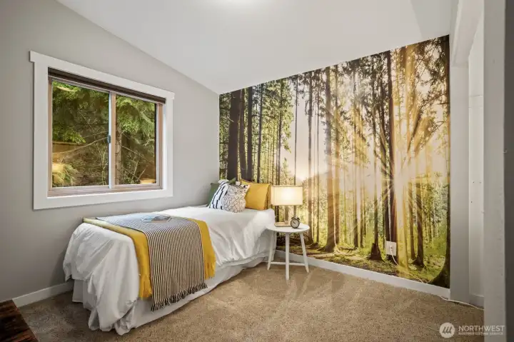 Charming second bedroom with vaulted ceiling and stylish wallpaper accents.
