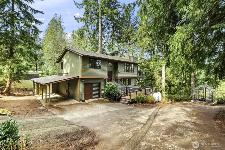 Ample parking and storage with an oversized garage, oversized carport, storage shed, and EV charger.