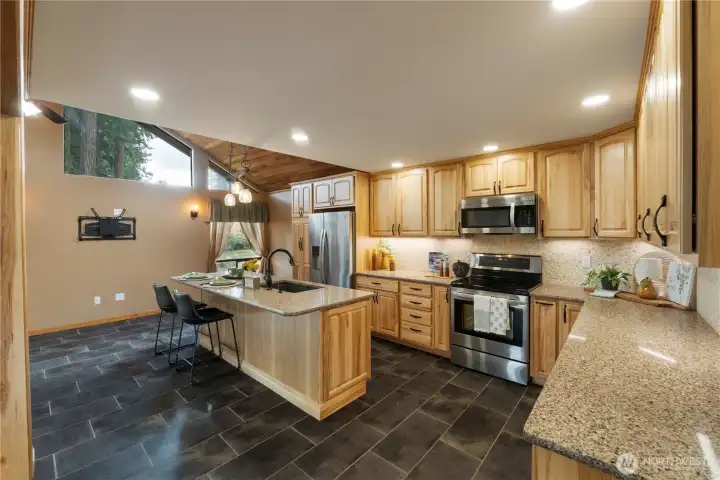 WOW!  So much to admire in this kitchen.  Updated in 2017, custom hickory cabinets feature quartz counters, soft close doors and drawers.  Even the lower cabinets have drawers.  Be sure to check out the custom cabinets next to the range.  With its expansive counters and abundant storage, this is a joy!