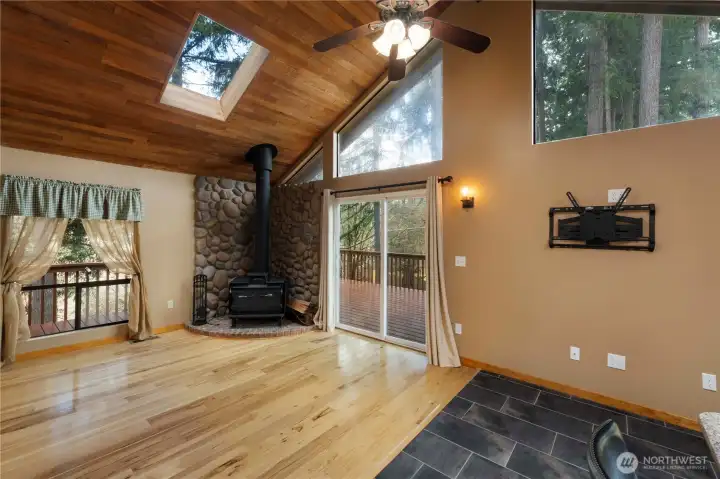 And talking about cozy, enjoy a family/media room just off your kitchen, featuring a wood burning stove, skylights and access to the wraparound deck.  So much natural light with windows, slider AND skylight.