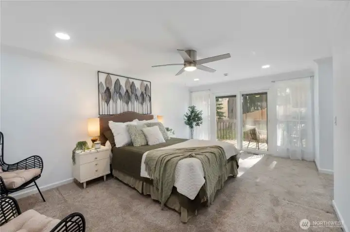 The spacious primary bedroom has plenty of room for your biggest furniture.  Newer, wonderfully cushy, freshly cleaned carpeting is a joy for your feet. The newer ceiling fan offers comfort on those warmer PNW nights, but the new slider is great for a little fresh air.