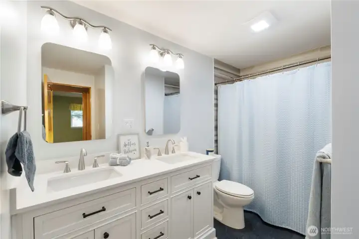 Even the updated guest bathroom has new quartz counters, soft close cabinetry, fixtures and tiled bath/shower.