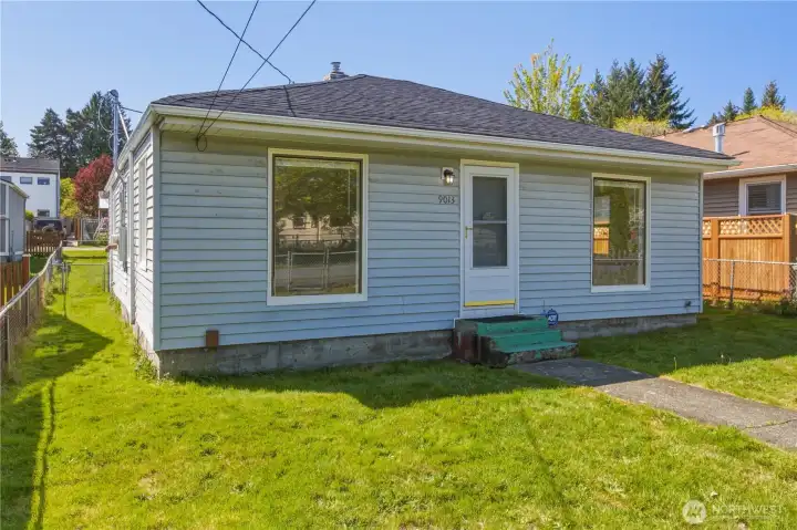 Large fenced yard with street parking out front and garage in the back.