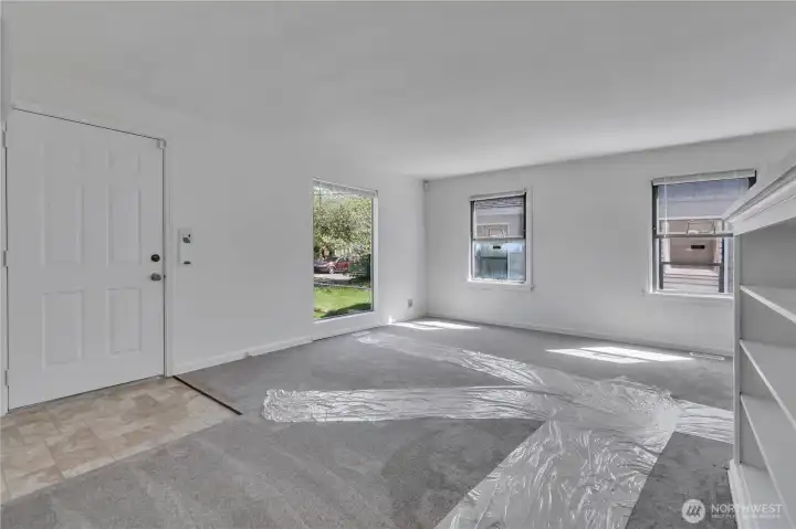 Spacious living room with windows that look out at the front yard.