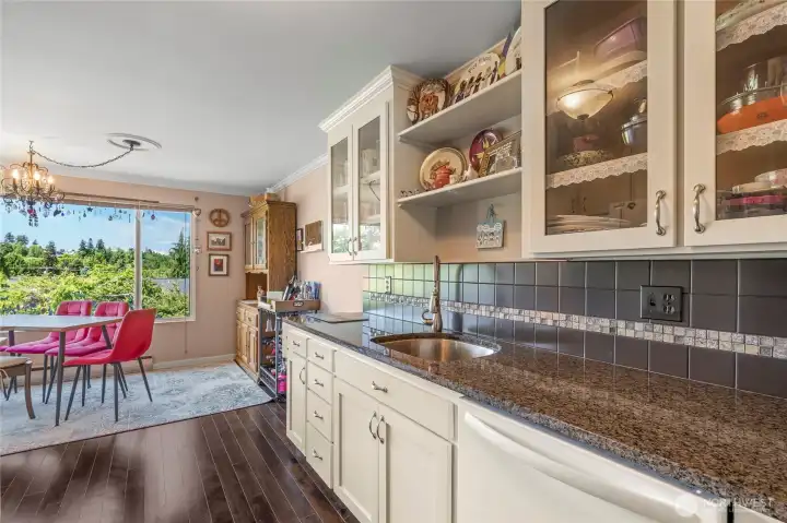 Updated kitchen with granite countertops, refreshed cabinetry, and flooring.
